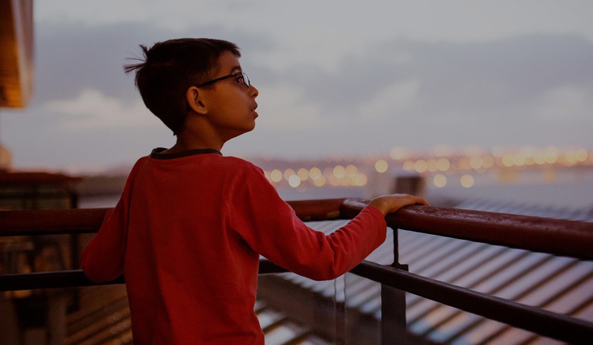 kid looking out balcony  